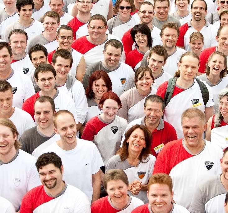 Große Gruppe lachender EWTO-Mitglieder in roten und weißen Shirts